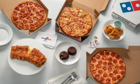 Pizza, side snacks, and dessert presented