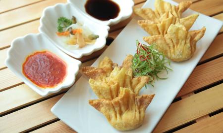 Crab rangoons with three toppings, on delicate white plates