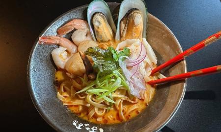 A bowl filled with noodles and various seafood