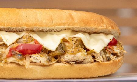 A sub filled with meat, cheese, and toppings