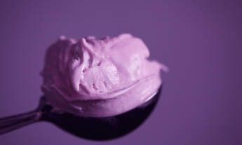 A scoop of ice cream is presented in front of a camera. 