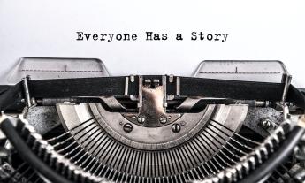 A classic old, black typewriter against a white background with the heading, "Everyone Has a Story"