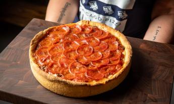 Deep dish pizza is positioned on a small table. 