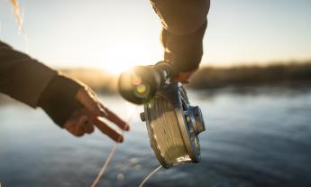 A man uses his fishing pole and line to capture fish. 