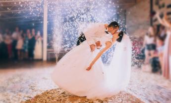 A couple swooning in for a kiss on the dance floor