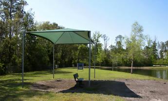 A bench under a shaded pavilion located at Davis Park