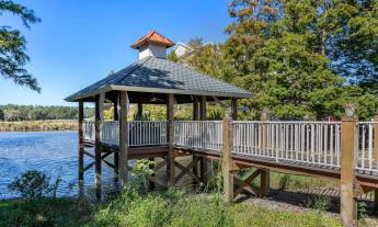 A gazebo at the end of a boardwalk that overlooks the water