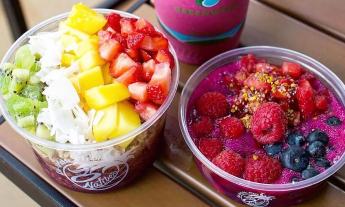 Acai bowls topped with fruit, granola, and coconut shavings