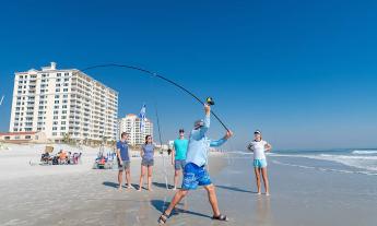 Noel Kuhn, surf fishing instructor, demonstrates casting on a clear, sunny day at the beach