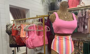 A rack of colorful swimsuits inside the store