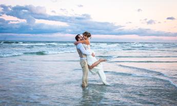 A couple celebrate in the surf after their beach wedding in St. Augustine. Photo by Sun and Sea Weddings.