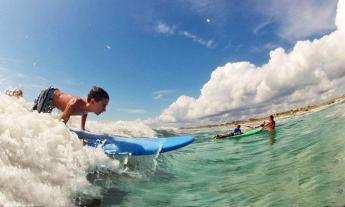 Students at a surf camp learning how to ride a wave in St. Augustine, Florida.