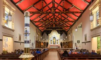 The nave of the Cathedral Basilica of St. Augustine in St. Augustine, Florida. Looking north towards the altar. The ceiling is painted red to honor the city’s Spanish origins, with the seal of each bishop painted on the beams. 