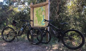 A map of the trails at Nocatee Preserve with bikes parked in front of the display