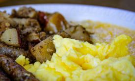 A breakfast plate of hash browns, scrambled eggs, and sausage.