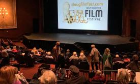 A theater with folks arriving to view a film festival