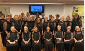 Women of the North Florida Women's Chorale, grouped for a formal photo, all wearing black dresses