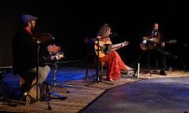 The three members of Zaza Flamenca, on stage, percussionist, and two vocalists with guitars