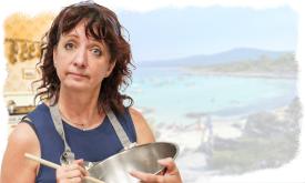 An actress protraying Shirley Valentine, wearing an apron and stirring a pot, while dreaming of Greece