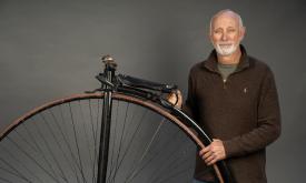 Keith Pariani standing next to one of his high-low bicycles
