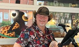 Gruuve, with his guitar at an outside venue.