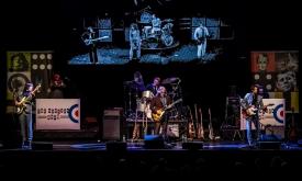 Bandmates from The Sixties Show perform live on stage.