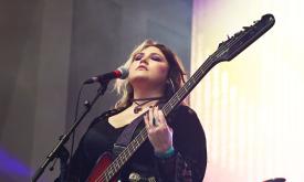Songwriter Cassidy Lee playing guitar on stage