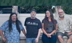 Saltones band sitting togeter in front of white fence