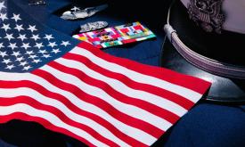 An American flag drapes over a military uniform.