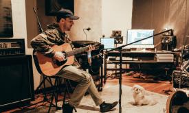 Musician Matt Still with his guitar in a studio