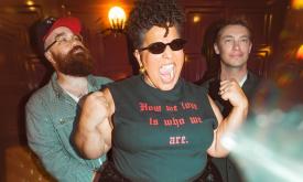 Members of Alabama Shakes stand together beneath warm, ambient lighting.