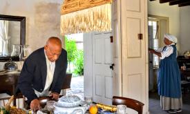 Two reenactors portraying black servants preparing a guest house 