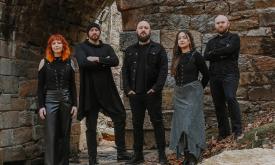 Members of SYR, a 5-person Celtic band, wearing black in front of an old fort or castle
