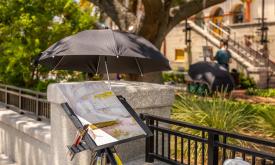 An artist's canvas set up in front of the Lightner Museum courtyard