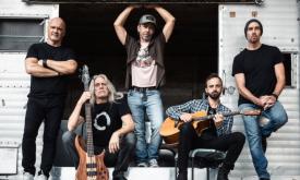 Bandmates from Given to Fly pose with their musical instruments.