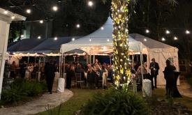 A sit-down dinner under lights at Peña-Peck House