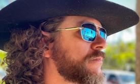 Side view of musician Banjo Brown in sunglasses and black hat