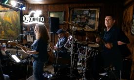 The trio, Ancient City Rock, on stage at TradeWinds Lounge