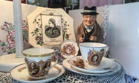 Teacups celebrating Victoria stand next to a small Winston Churchill figurine at the Linen Room. 