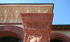A close up of a pillar at the entranceway of the Hotel Ponce de Leon in St. Augustine, Florida. It is orange terra cotta and has the face of a lion carved into it.