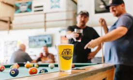 Playing pool with a craft beer at Ancient City Brewing in St. Augustine.