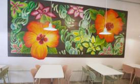 Seating under a custom-painted mural at Juniper Market on 48 San Marco in St. Augustine.