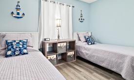 A guest bedroom in one of Ocean & Racquet's units, featuring comfortable twin beds.