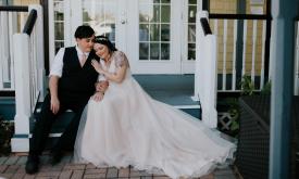 A bridal couple on the steps of the Bayfront Marin House in St. Augustine. Photo by Apaige Photography.