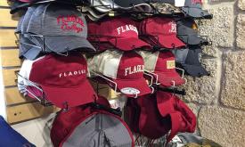 An assortment of hats bearing Flagler College logos and identifiers.