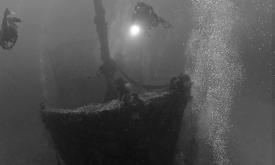 Divers searching a wreck deep under the sea, an image from the St. Augustine Shipwreck Museum and Gallery.