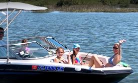 A family enjoys the sun on the water in a boat from Summer Breeze Boat Rental in St. Augustine.