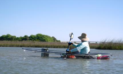 A kayaker in a transparent kayak with a view of Vilano Bridge