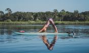 A girl practicing yoga on a stand-up paddle board on the waters around St. Augustine.