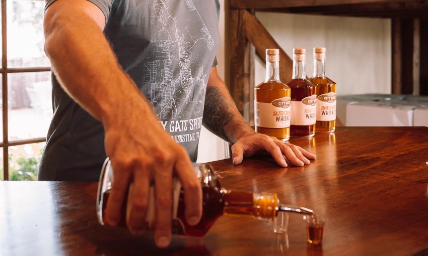 A tasting guide at City Gate Spirits on San Marco pours a free taste for a guest.
